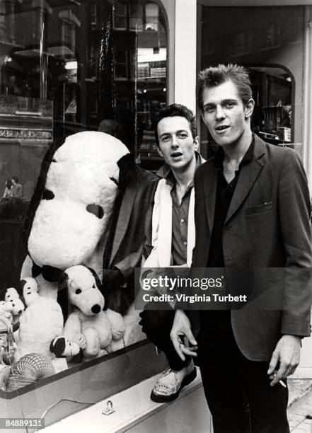 Photo of Paul SIMONON and Joe STRUMMER and CLASH; Joe Strummer & Paul Simonon, posed outside shop in Leicester Square,