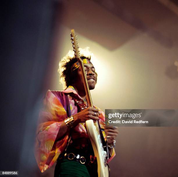 American rock guitarist and singer Jimi Hendrix performs live on stage playing a white Fender Stratocaster guitar with The Jimi Hendrix Experience at...