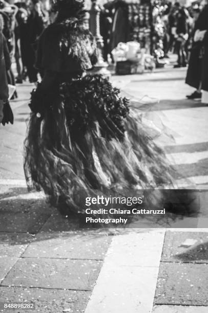 masked woman walking in venice viewed from behind in a b/w image - fiesta posterior stock pictures, royalty-free photos & images