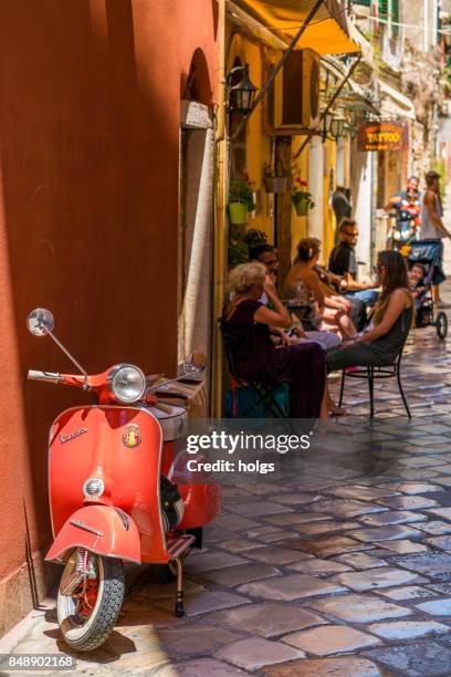 vespa scooter in een smalle laneway van oude corfu-stad, griekenland - vespa scooter stockfoto's en -beelden