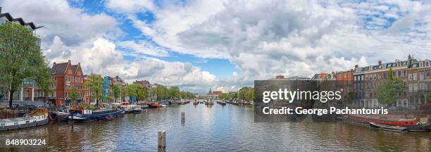 panorama of amstel river, amsterdam, netherlands - amsterdam skyline stockfoto's en -beelden