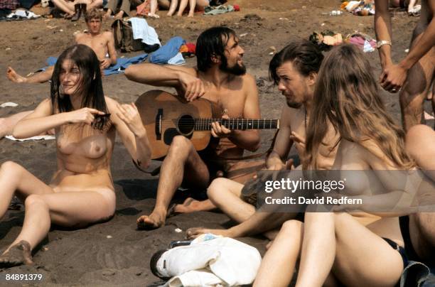 Photo of NAKED and HIPPIES and FANS and FESTIVALS; naked hippies sit on the beach on the Isle of Wight during the festival
