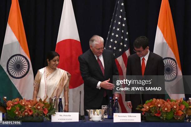 Secretary of State Rex Tillerson shakes hands with Japan's Foreign Minister Taro Kono as India's Foreign Minister Sushma Swaraj looks on before a...