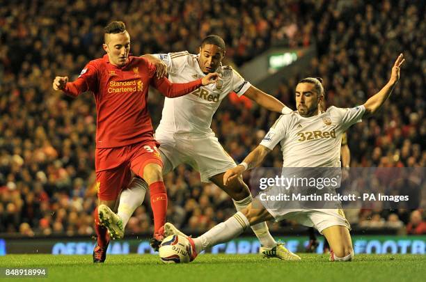 Swansea City's Ashley Williams and Chico battle for the ball with Liverpool's Samed Yesil