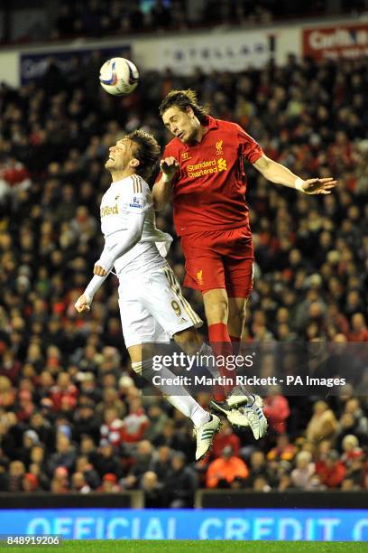 Swansea City's Miguel Michu and Liverpool's Sebastian Coates battle for the ball in the air