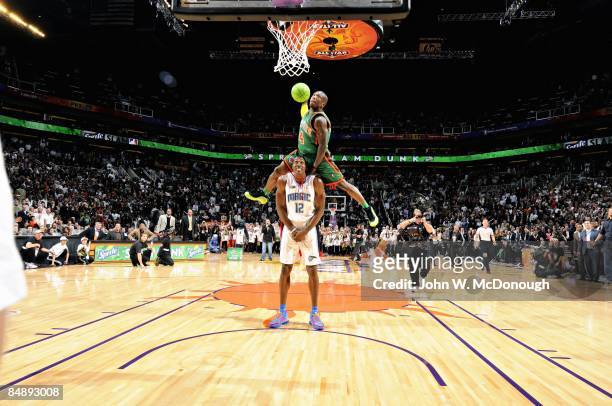 Slam Dunk Contest: New York Knicks Nate Robinson in action, leaping over Orlando Magic Dwight Howard during finals on All-Star Saturday Night of All...