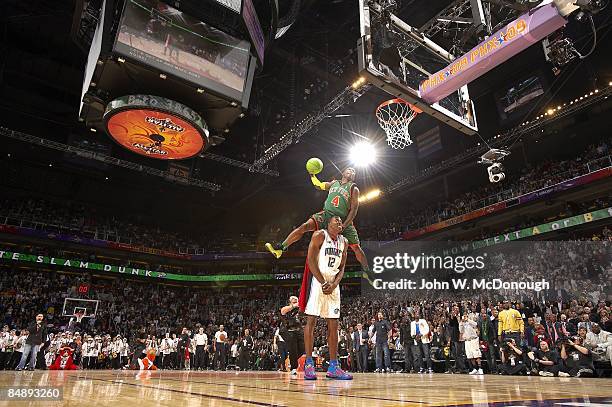 Slam Dunk Contest: New York Knicks Nate Robinson in action, leaping over Orlando Magic Dwight Howard during finals on All-Star Saturday Night of All...