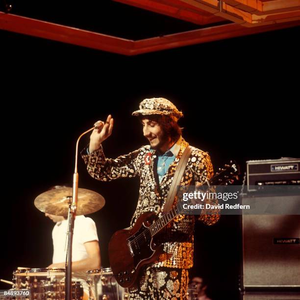 Drummer Keith Moon and guitarist Pete Townshend, dressed as a pearly king and playing a Gibson SG Special guitar, perform on stage with English rock...