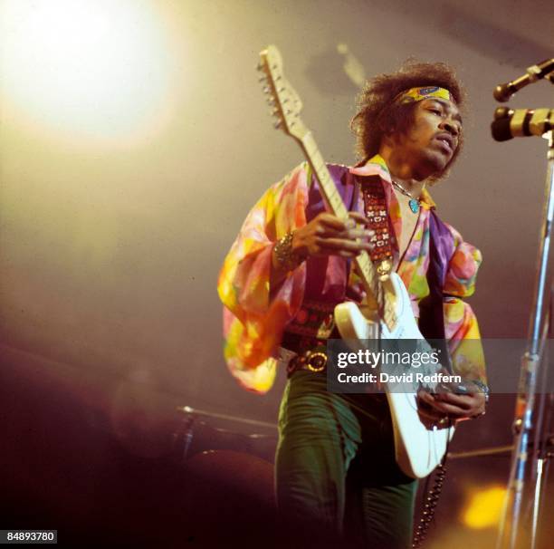 American rock guitarist and singer Jimi Hendrix performs live on stage playing a white Fender Stratocaster guitar with The Jimi Hendrix Experience at...