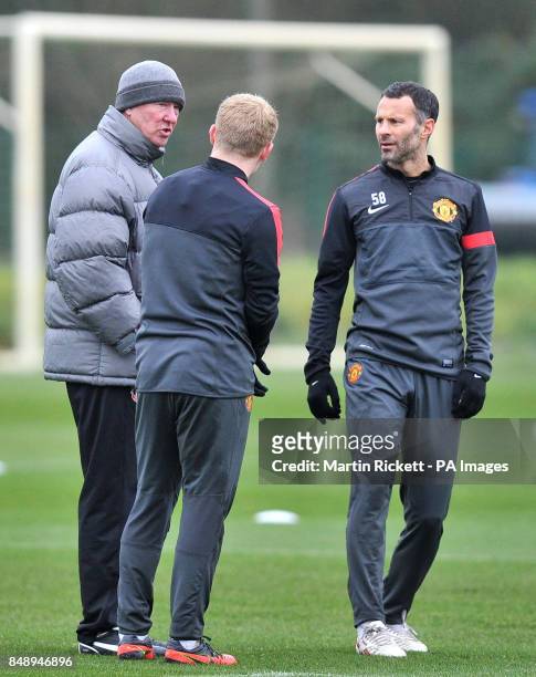 Manchester United manager Sir Alex Ferguson talks with Ryan Giggs and Paul Scholes during a training session at Carrington Training Ground,...