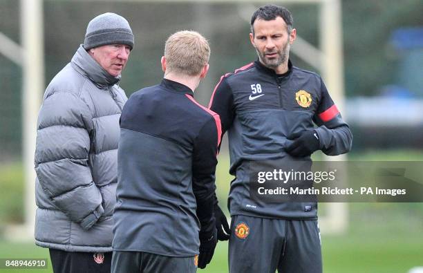 Manchester United manager Sir Alex Ferguson talks with Ryan Giggs and Paul Scholes during a training session at Carrington Training Ground,...