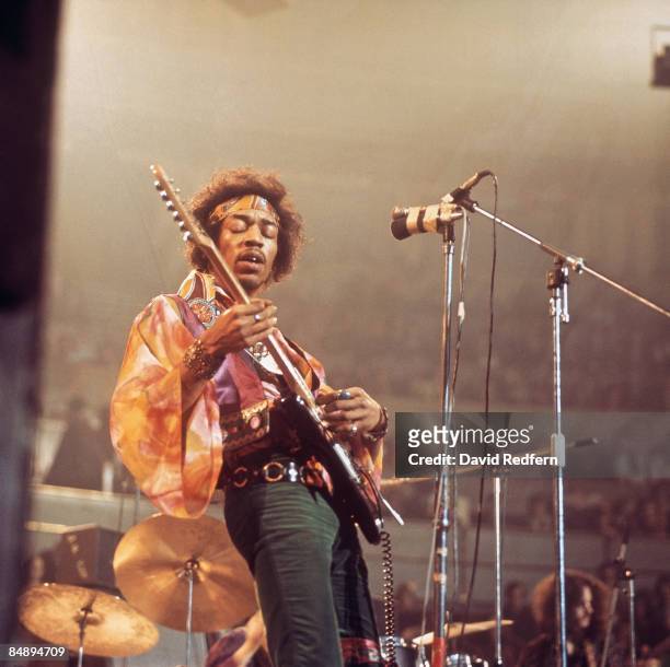 American rock guitarist and singer Jimi Hendrix performs live on stage playing a black Fender Stratocaster guitar with The Jimi Hendrix Experience at...