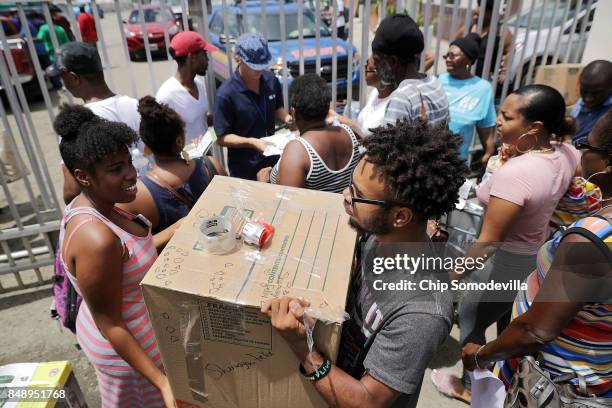 Passengers carry supplies onto a ferry taking them to St. Thomas more than a week week after Hurricane Irma made landfall September 17, 2017 in...