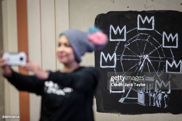 Member of the public takes a selfie photograph by a new work by street artist Banksy on a wall by the Barbican Centre on September 18, 2017 in...