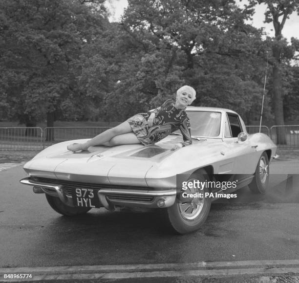 Lisa Noble reclines on the bonnet of her Chevrolet Stingray car in Hyde Park, London. A former telephone switchboard operator, she was given the...