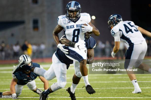 University of Maine's Jaleel Reed tries to elude University of New Hampshire defenders Thursday, August 31, 2017.