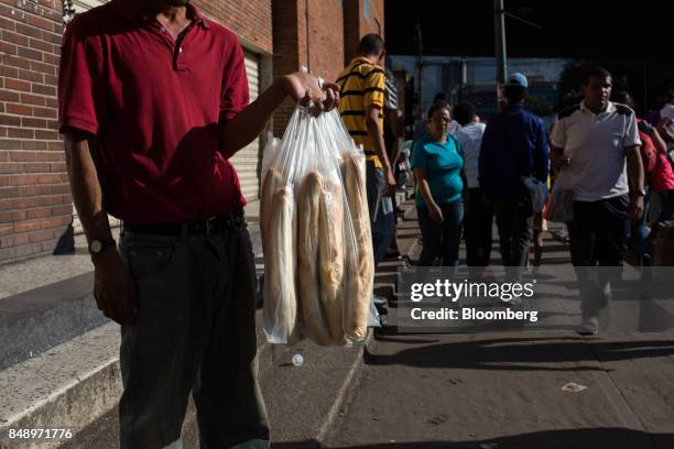 Peddler sells canillas, banquette-like bread popular in the country for decades, on a street in Caracas, Venezuela, on Wednesday, Aug. 30, 2017. The...