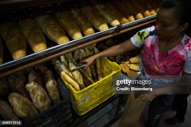 An employee bags canillas, banquette-like bread popular in the country for decades, for a customer at a bakery in Caracas, Venezuela, on Wednesday,...