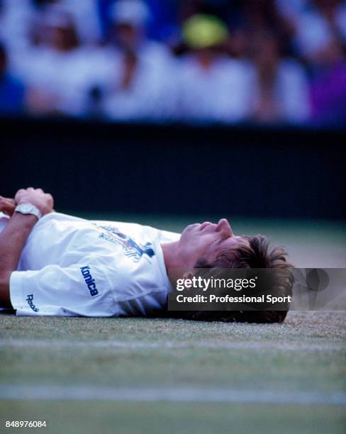 Michael Stich of Germany lies on the ground during a men's singles match at the Wimbledon Lawn Tennis Championships, circa July 1993. Stich was...