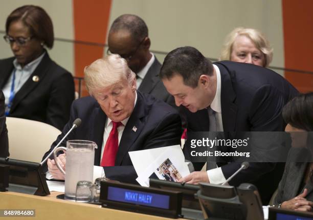 President Donald Trump, left, is briefed before a panel discussion at the UN General Assembly meeting in New York, U.S., on Monday, Sept. 18, 2017....
