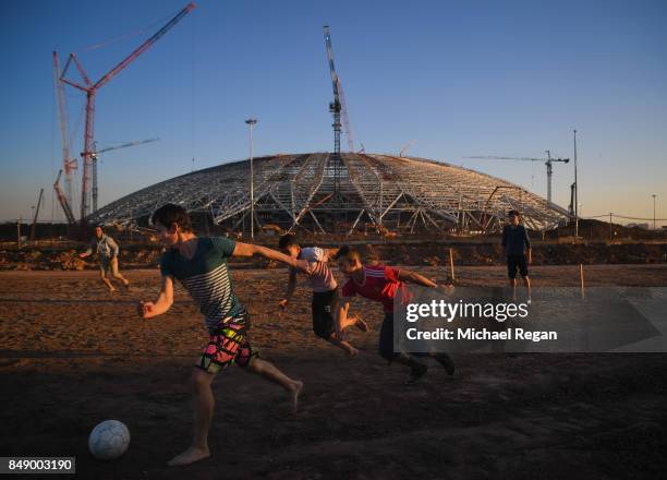 Men play football on the construction site of the Samara Arena on September 17, 2017 in Samara, Russia.