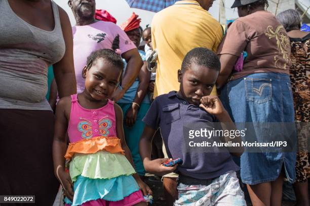 Residents wait a distribution of food and water in front of Saint Martin III's College in the Orleans neighborhood, eleven days after the passage of...