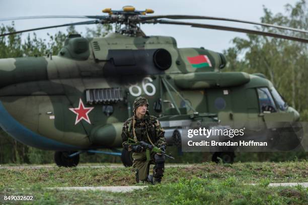 Belarusian soldier guards a helicopter at the Asipovichy military training ground during the Zapad 2017 military exercises on September 18, 2017 in...