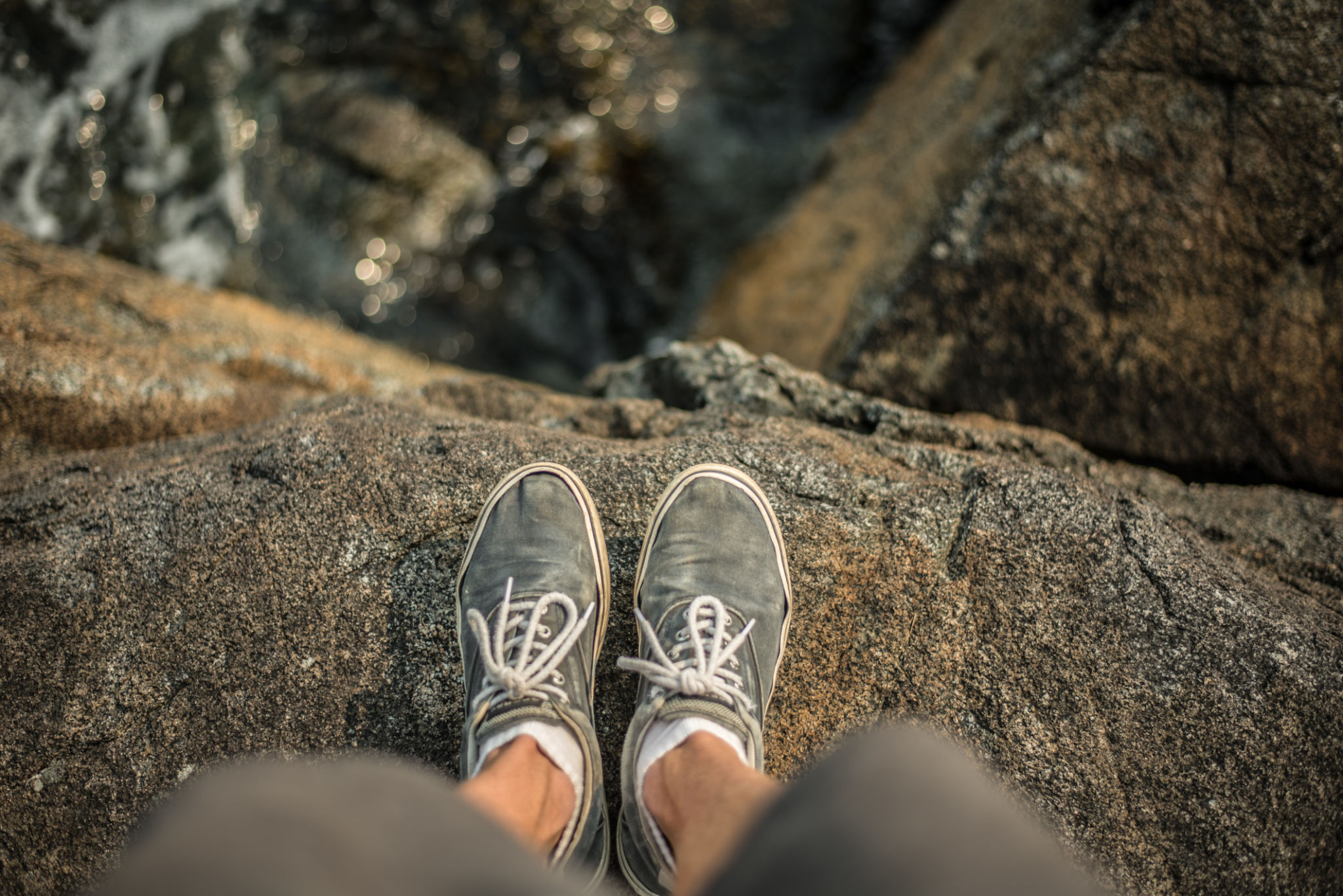 Shoes standing on the edge of cliff over ocean Shoes standing on the edge of cliff over ocean