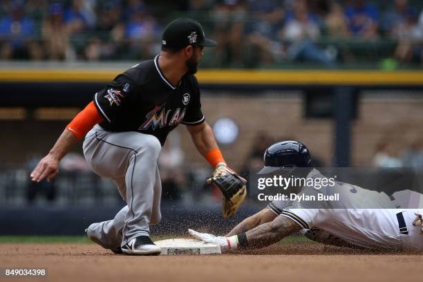 Jonathan Villar of the Milwaukee Brewers slides into second base for a double past Mike Aviles of the Miami Marlins in the eighth inning at Miller...