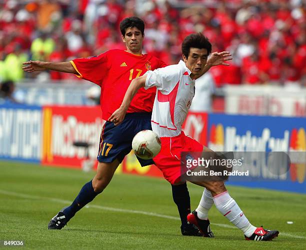 Juan Valeron of Spain tries to tackle Jin Cheul Choi of South Korea during the FIFA World Cup Finals 2002 Quarter Finals match played at the Gwangju...