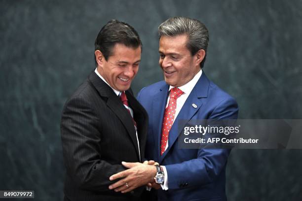 Mexican President Enrique Pena Nieto and Mexican businessman Carlos Peralta Quintero greet each other during the announcement of investment in...