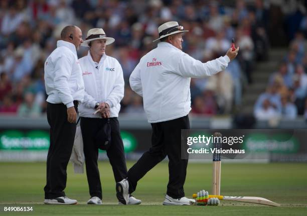 Umpire Marais Erasmus takes a light reading as Christopher Gaffaney and Tim Robinson look on during Day One of the 3rd Investec Test Match between...