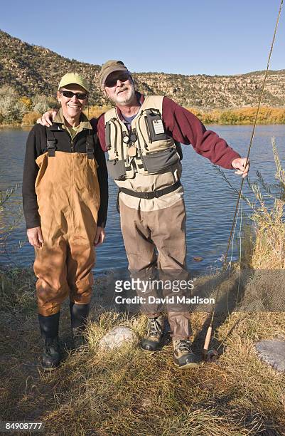 fly-fishing couple wearing waders. - waders stock-fotos und bilder