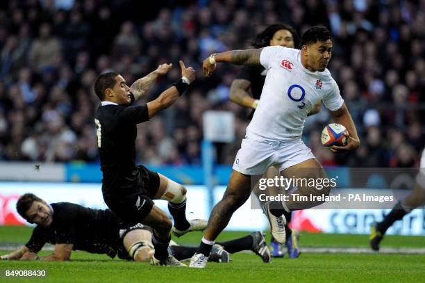 England's Manu Tuilagi breaks a tackle during the QBE International at Twickenham Stadium, London.