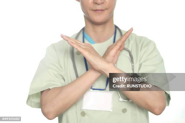 close up of doctor with opposing hand gesture - cross shape ストックフォトと画像