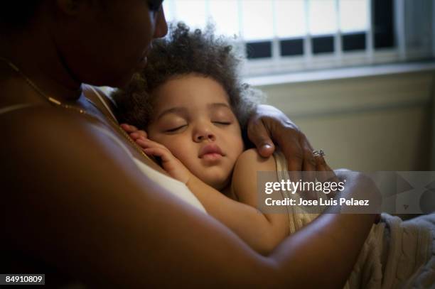 mother holding sleeping son - baby hug stockfoto's en -beelden