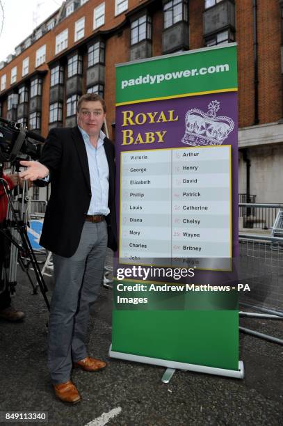 Paddy Power poses with a board of Royal baby names and their odds outside the King Edward VII hospital in London where the Duchess of Cambridge has...