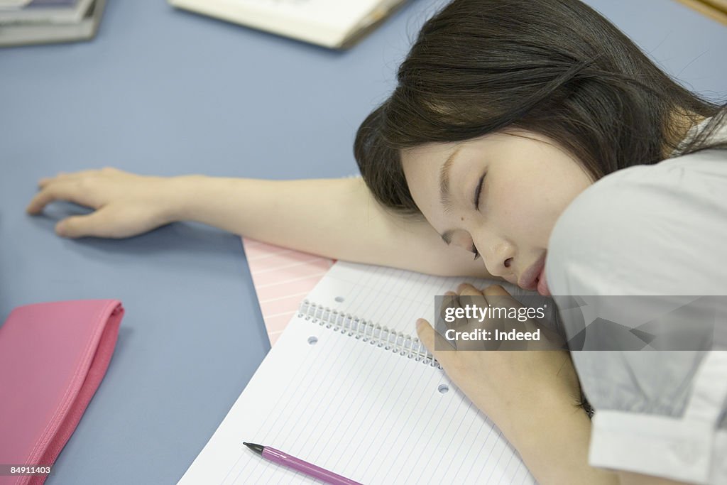 Young woman sleeping on desk