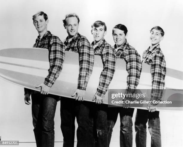 Photo of BEACH BOYS; L-R: Brian Wilson, Mike Love, Dennis Wilson, Carl Wilson, David Marks posed with surfboard