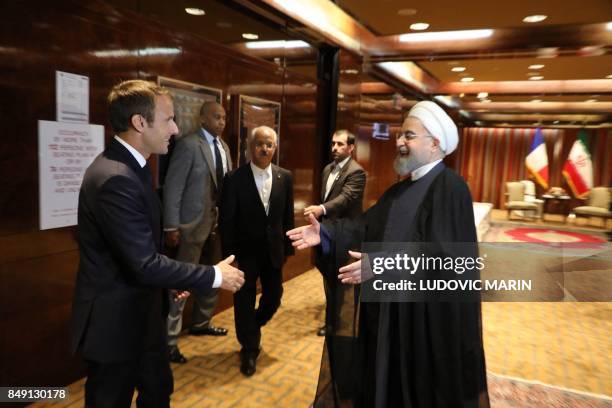 France's president Emmanuel Macron greets Iranian president Hassan Rouhani at the Millennium Hotel near the United Nations on September 18 in New...