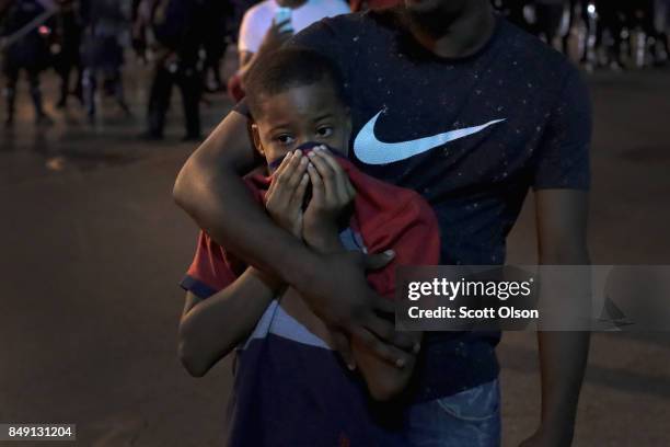 Man protects a boy as police move in and spray mace for a mass arrest downtown during a protest of the acquittal of former St. Louis police officer...