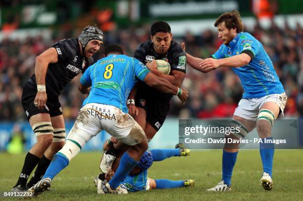 Leicester's Manu Tuilagi is tackled by Treviso's James Ambrosini, Manoa Vosawai and Antonio Pavanello during the Heineken Cup Pool Two match at...