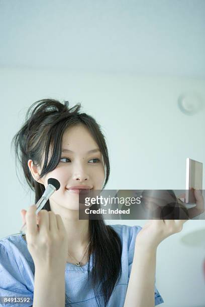 japanese woman applying blush, smiling - japanese brush stroke stock pictures, royalty-free photos & images