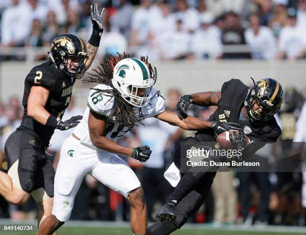 Cornerback Darius Phillips of the Western Michigan Broncos intercepts a pass intended for wide receiver Felton Davis III of the Michigan State...