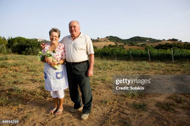 mature couple standing in field - italy countryside stock-fotos und bilder