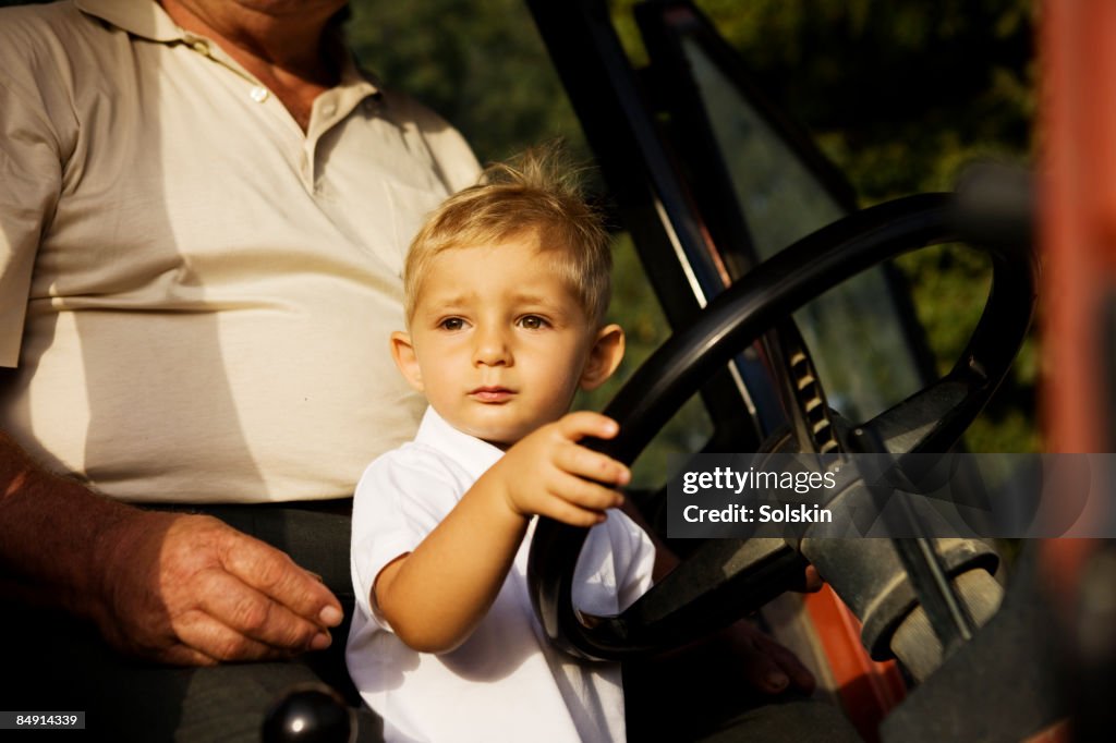 Boy pretending to drive tractor