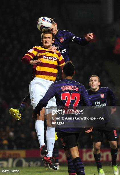 Arsenal's Thomas Vermaelen and Bradford City's James Hanson battle for the ball in the air