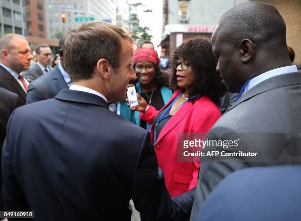 France's President Emmanuel Macron talks to people from Haiti as he walks through the streets of New York to the French mission at the United Nations...
