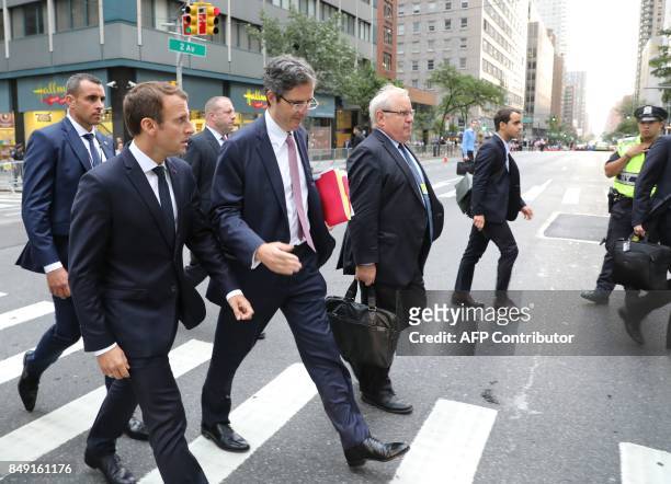 France's President Emmanuel Macron crosses 2nd Avenue as he walks to the French mission at the United Nations after a meeting with the Iranian...
