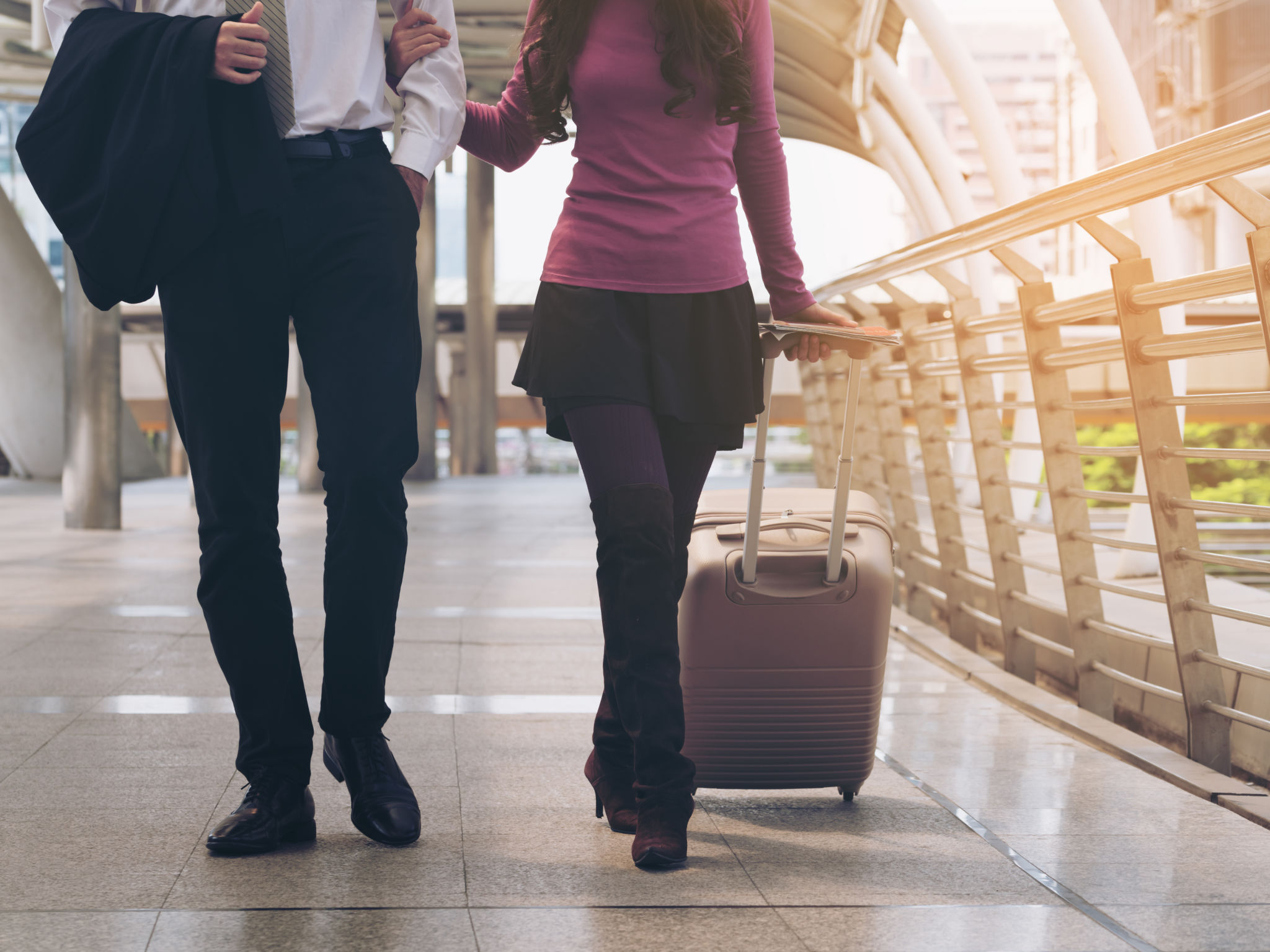 Couple travellers walking in airport walkway Couple travellers walking in airport walkway